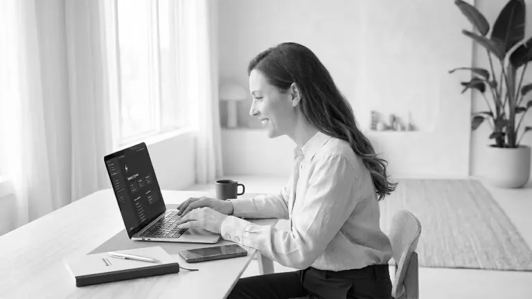 Woman working on laptop at bright home desk