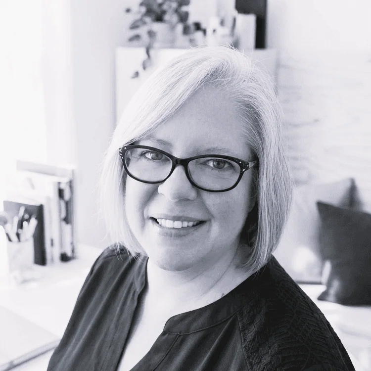 Black-and-white portrait of smiling woman with glasses